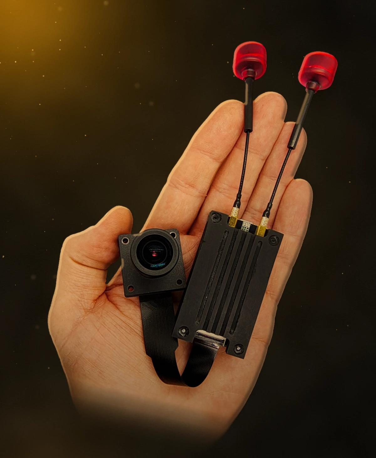Hand holding the OBRION video module with two red antennas