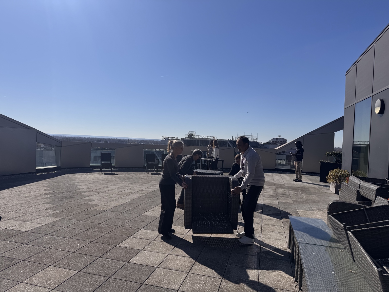Participants moving terrace furniture during a practical manual handling activity