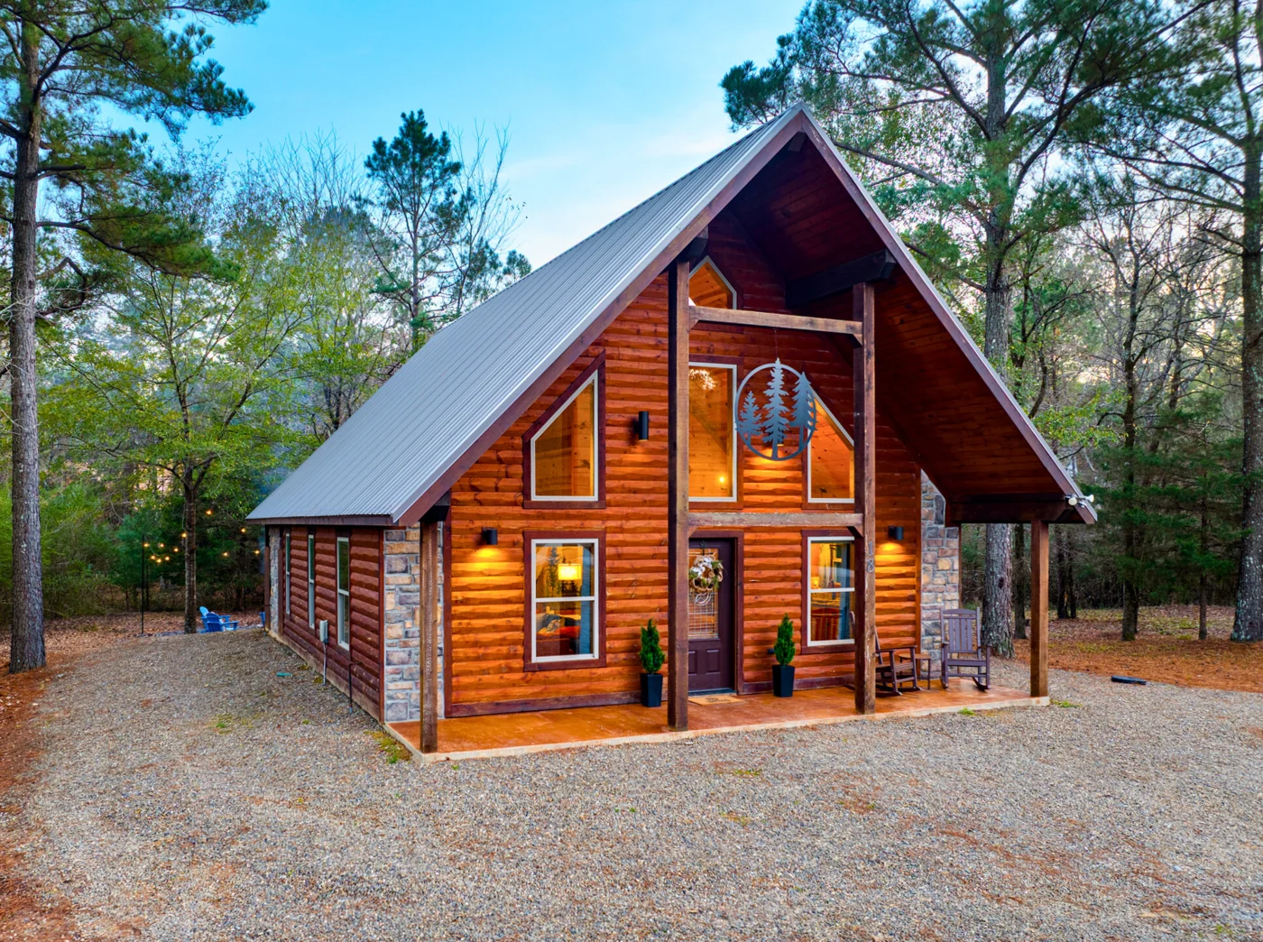 The timber A-frame exterior of Hearth and Heritage among the trees in Hochatown
