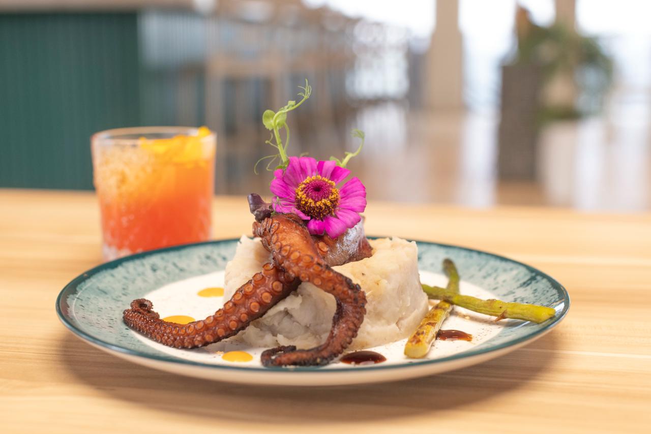 Plato de pulpo y un cóctel junto al mar en Joyuda