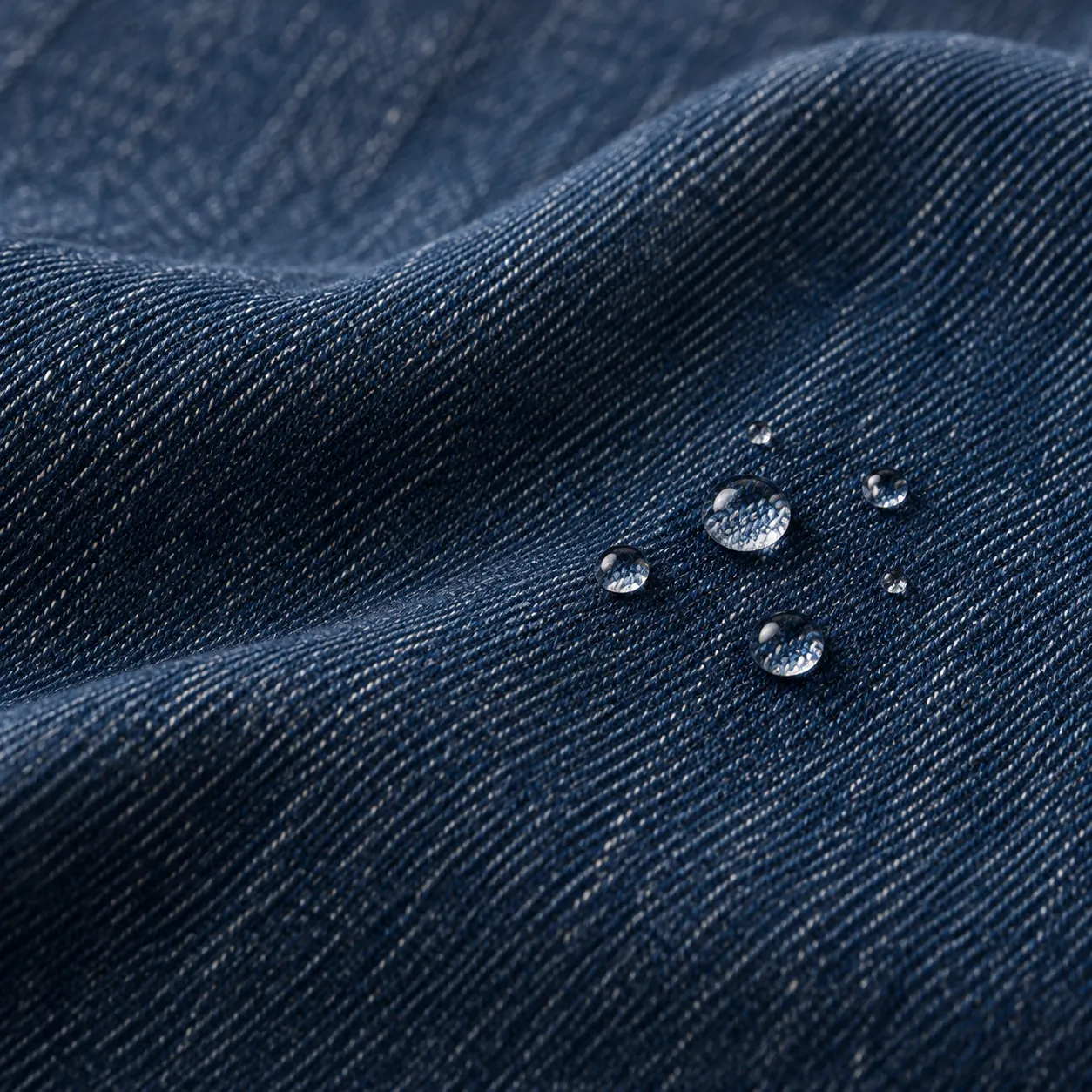 Freshly rinsed dark indigo denim with small clear water droplets.