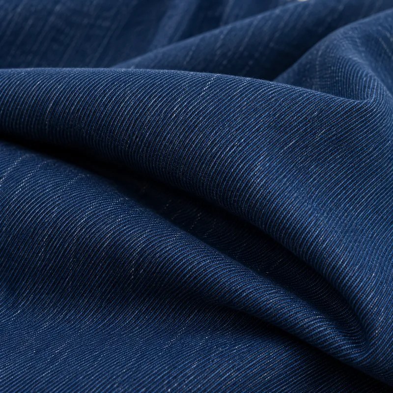 Deep evenly dyed indigo denim with a broad natural fold.