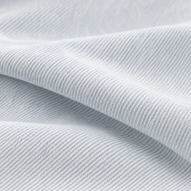 Luminous near-white denim with a pale blue undertone and soft fold.