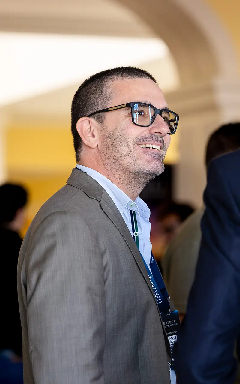 A delegate smiles while conversing beneath an archway at the venue