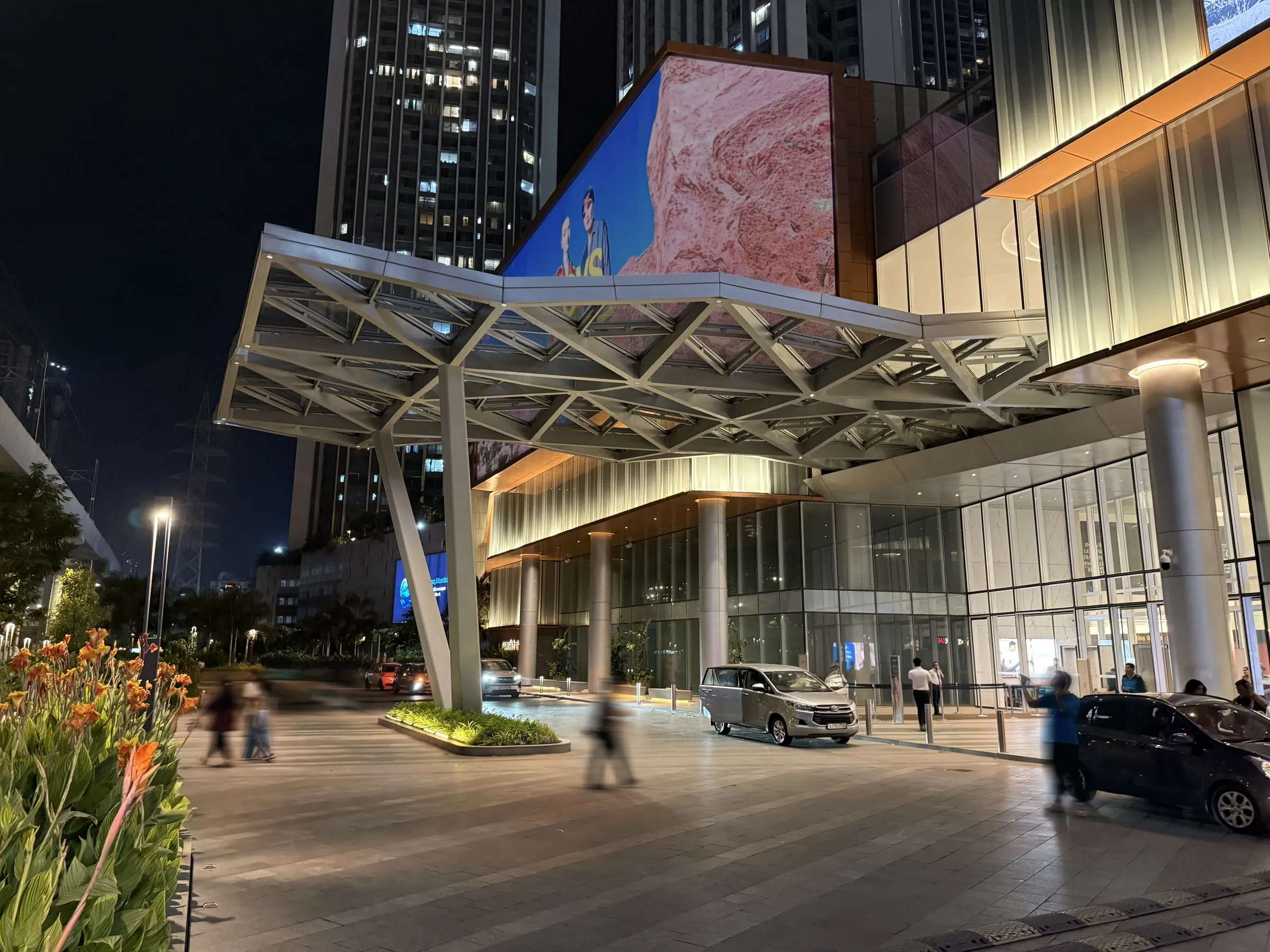 Lit steel entrance canopy and glazed facade of SkyCity Mall at night, Mumbai