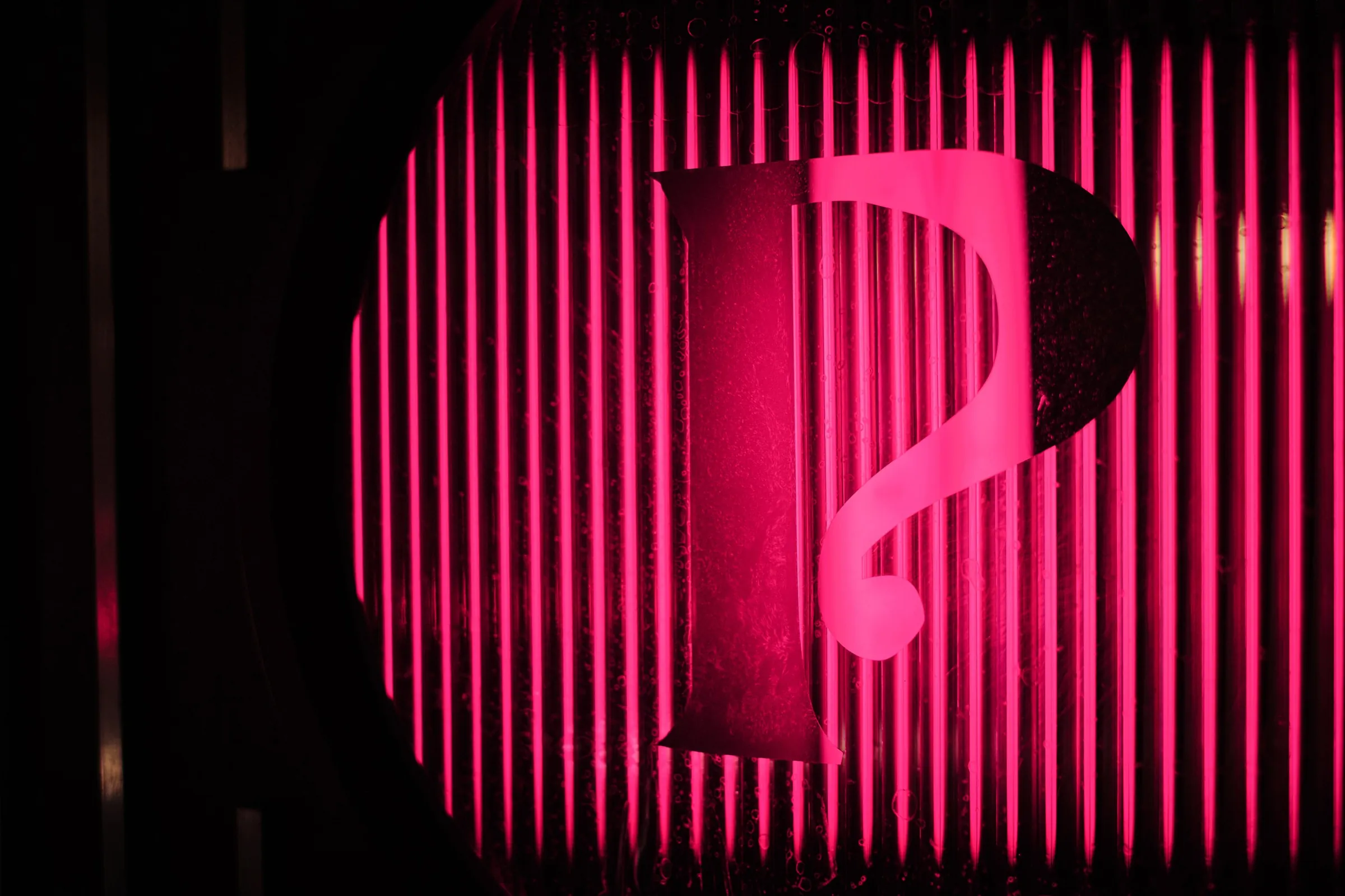 Pink neon 'P' sign behind fluted glass at The Porter's Store