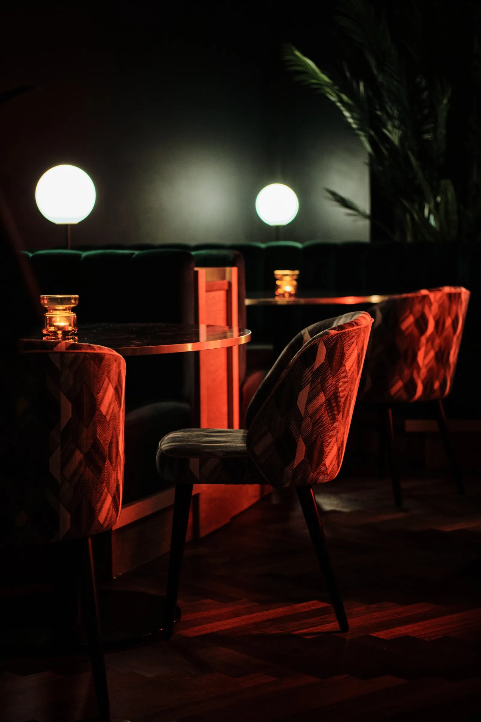 Red quilted chairs and globe lamps around a low table at The Porter's Store