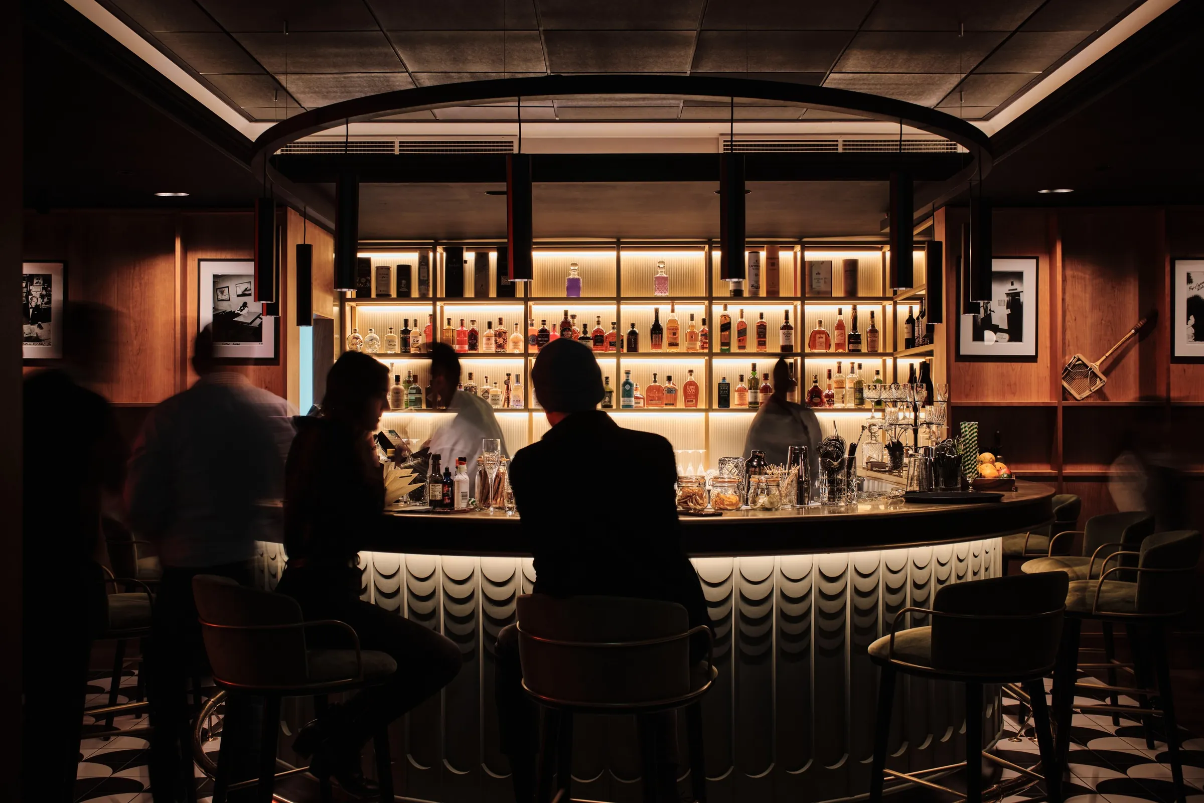 Guests at the curved, back-lit bar of The Porter's Store cocktail bar, St Helier, Jersey