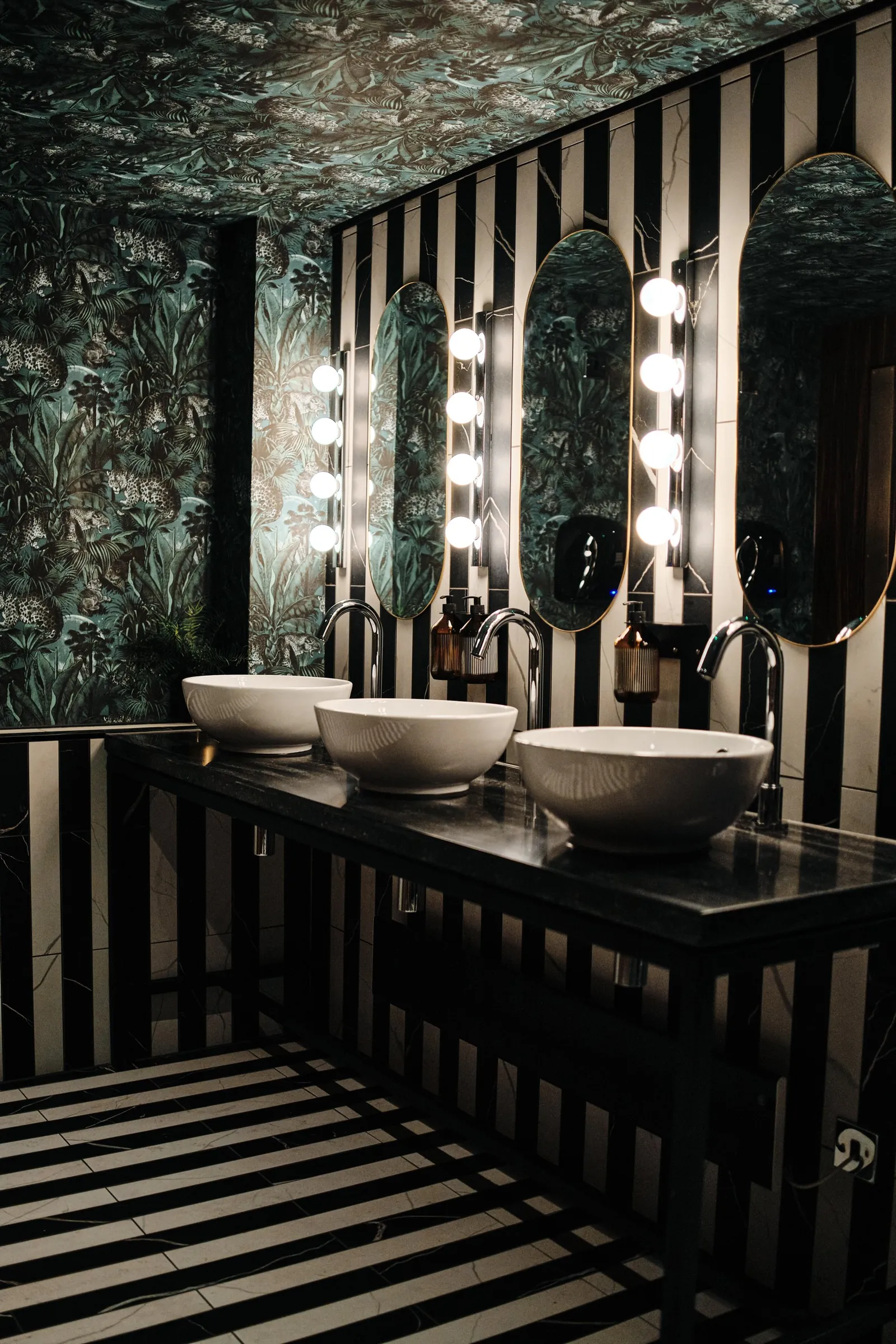 Washroom at The Porter's Store with striped tiles, botanical wallpaper and bowl basins