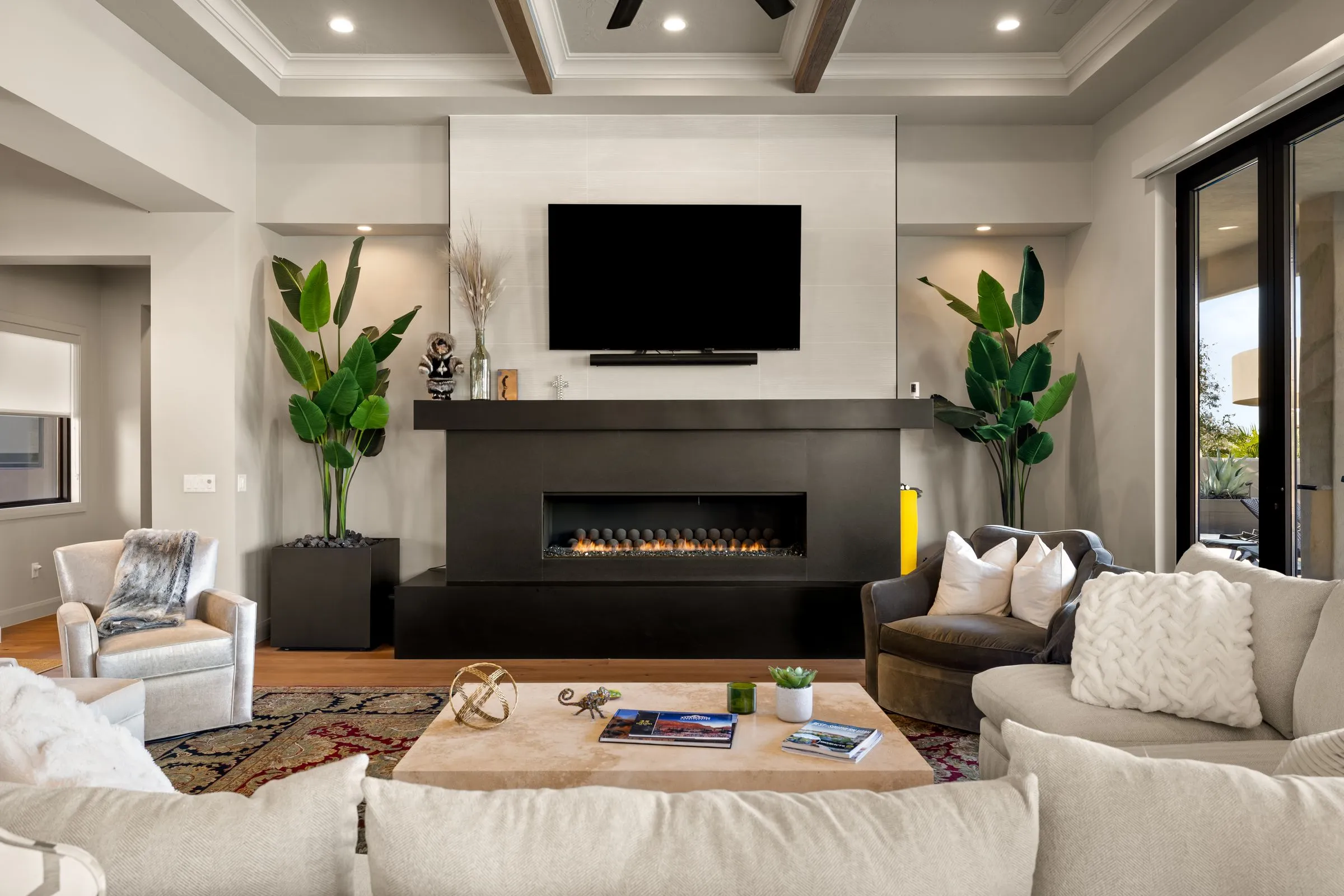 Living room with a linear fireplace and coffered ceiling