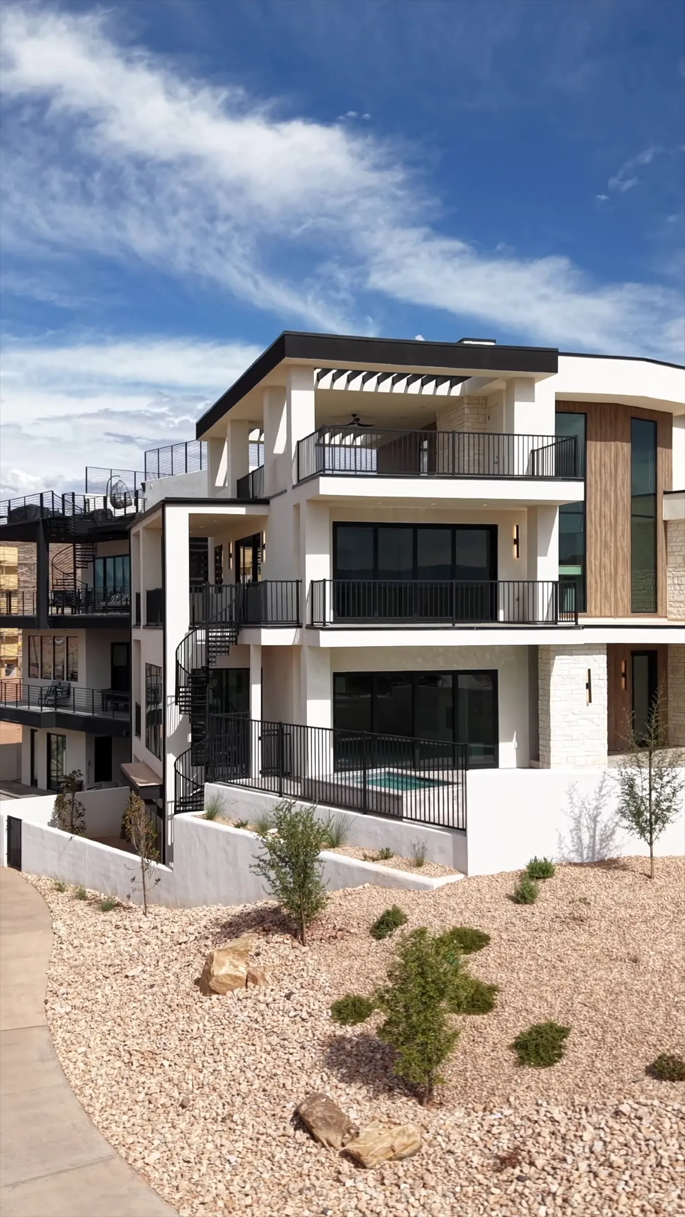 Three story modern home with balconies and a desert landscaped yard