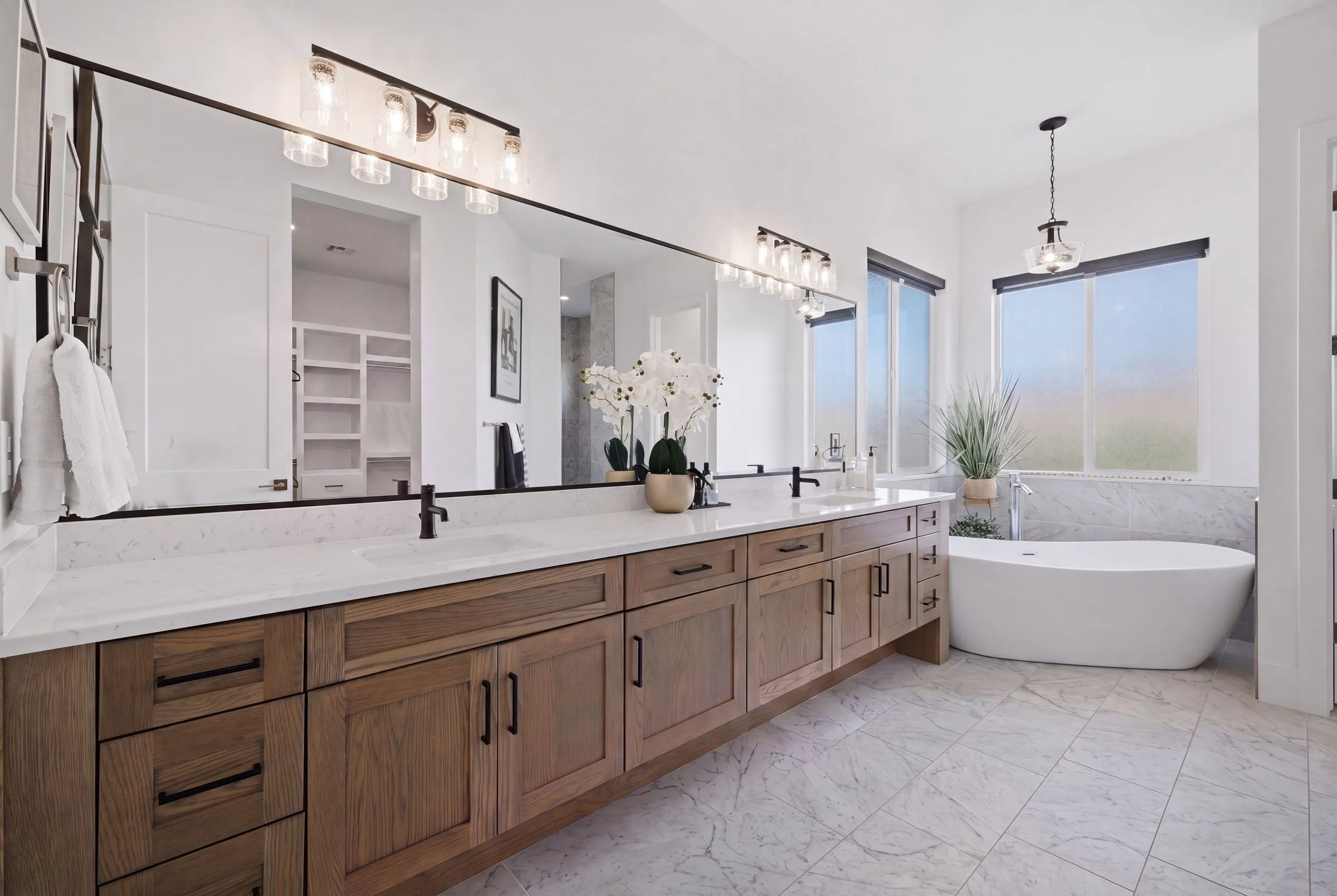 Primary bathroom with a long vanity and freestanding tub