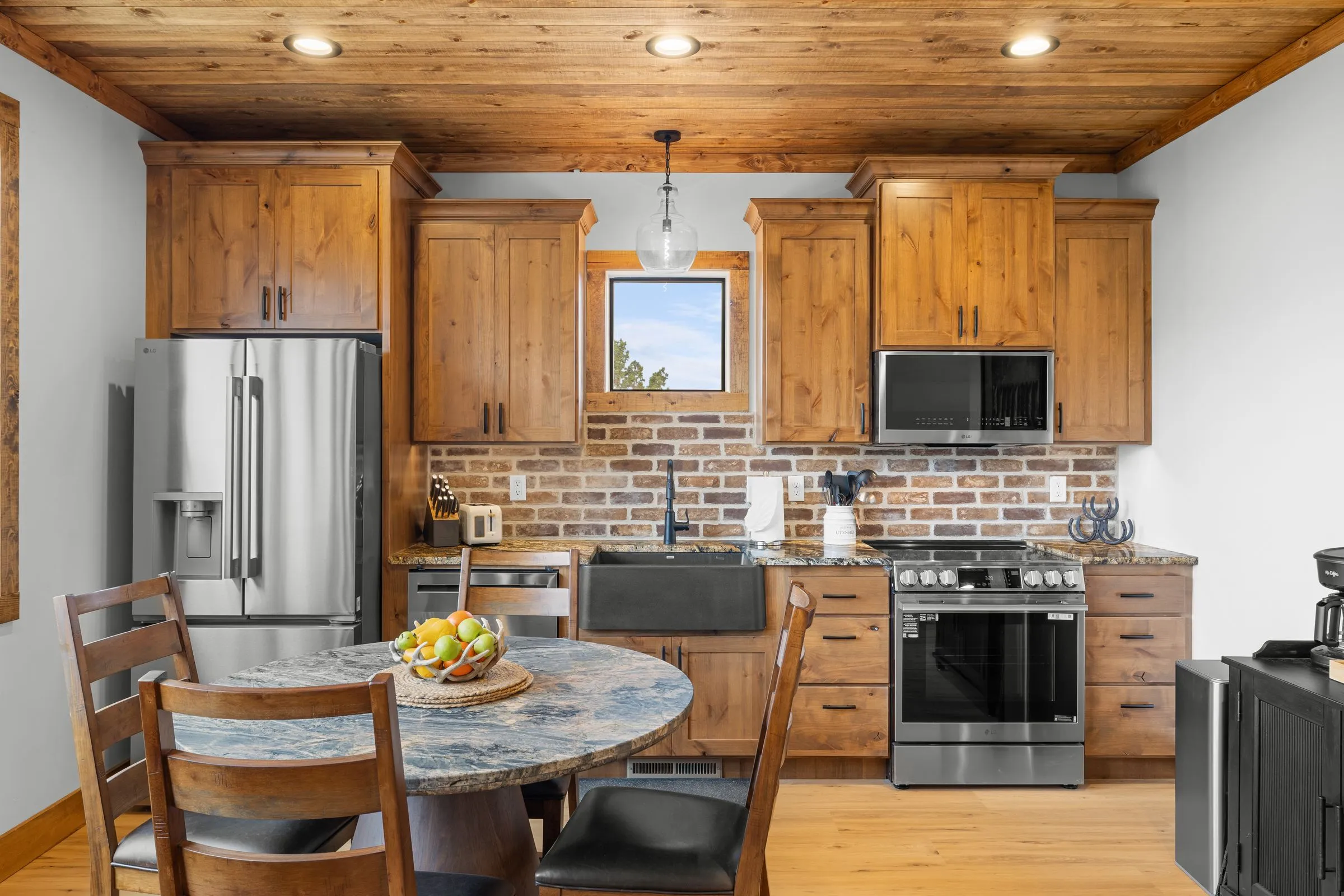 Kitchen with wood cabinets, a brick backsplash and a round dining table
