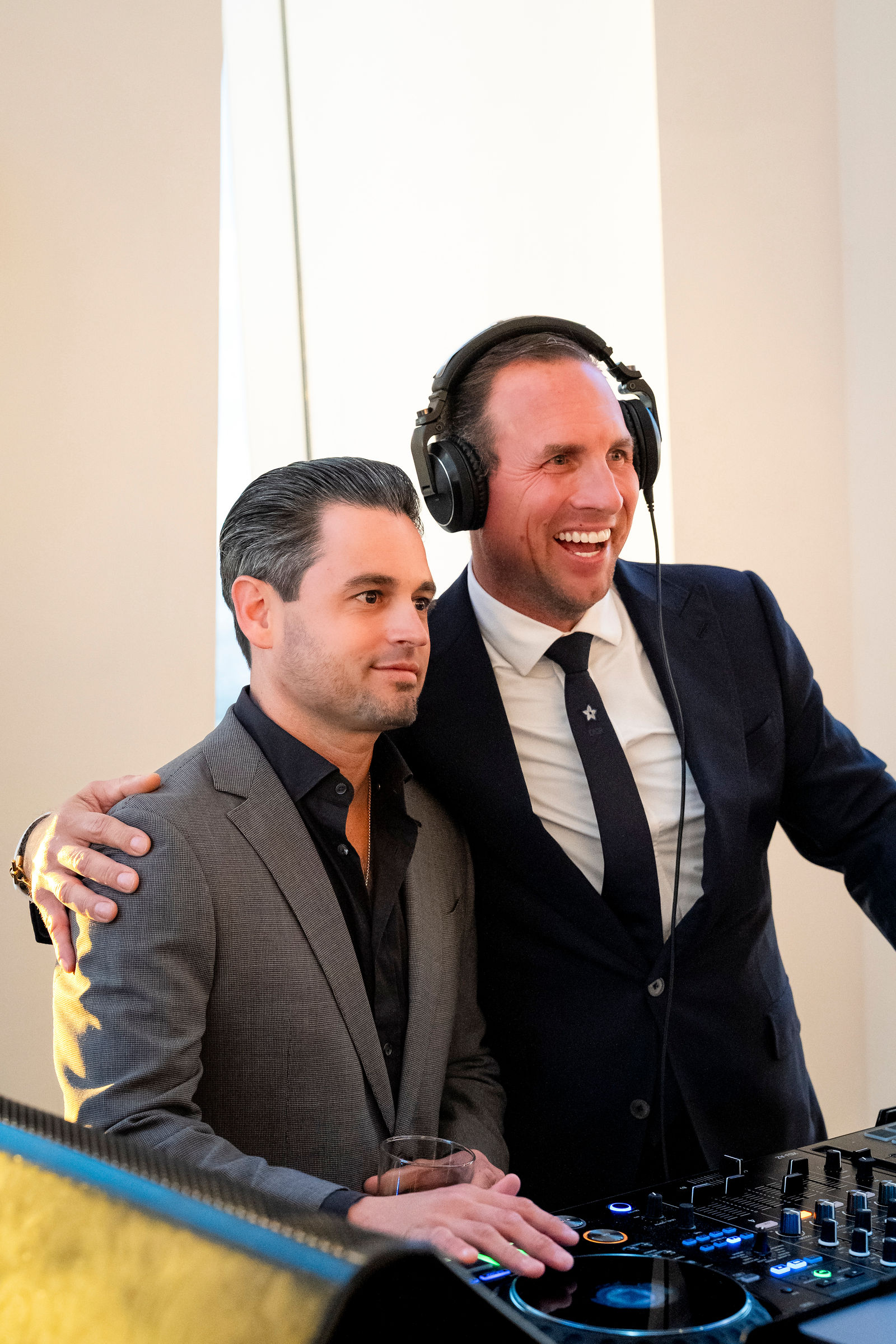 The DJ and a guest laughing together at the decks