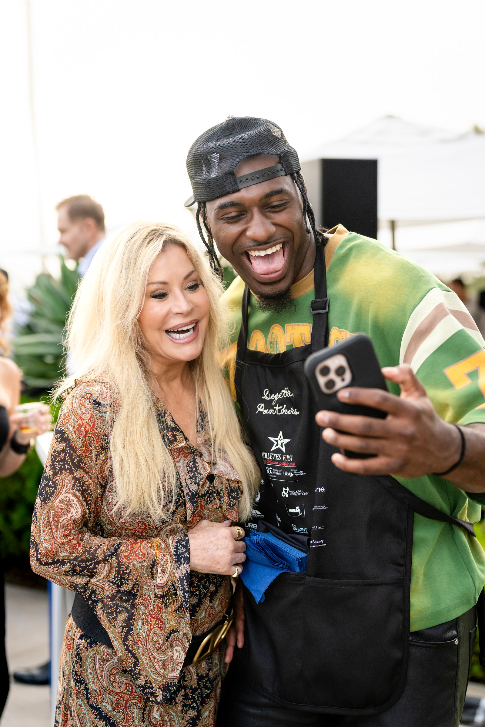 A guest taking a selfie with an athlete at Celebrity Waiter Night