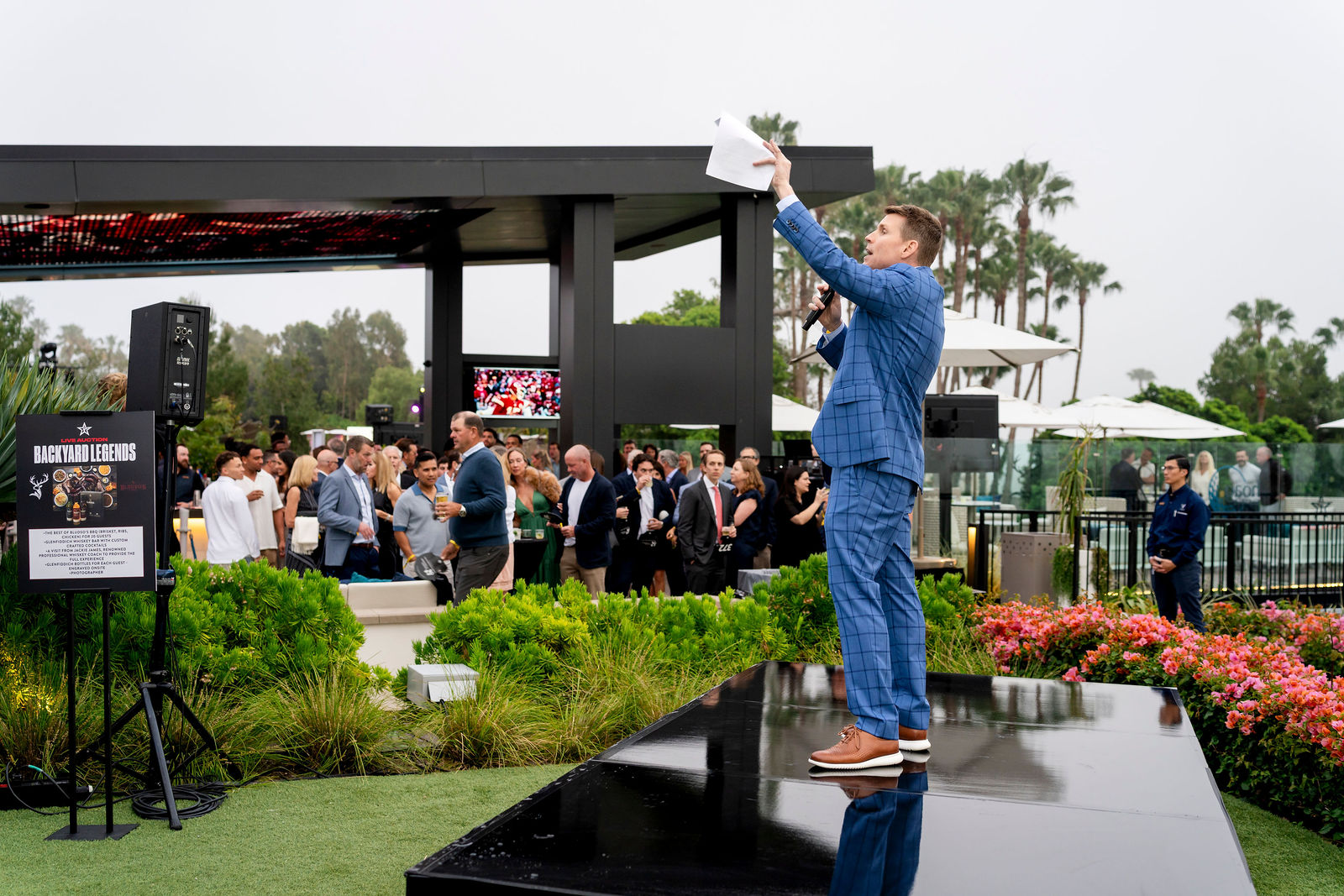 The auction host addressing the crowd from the stage