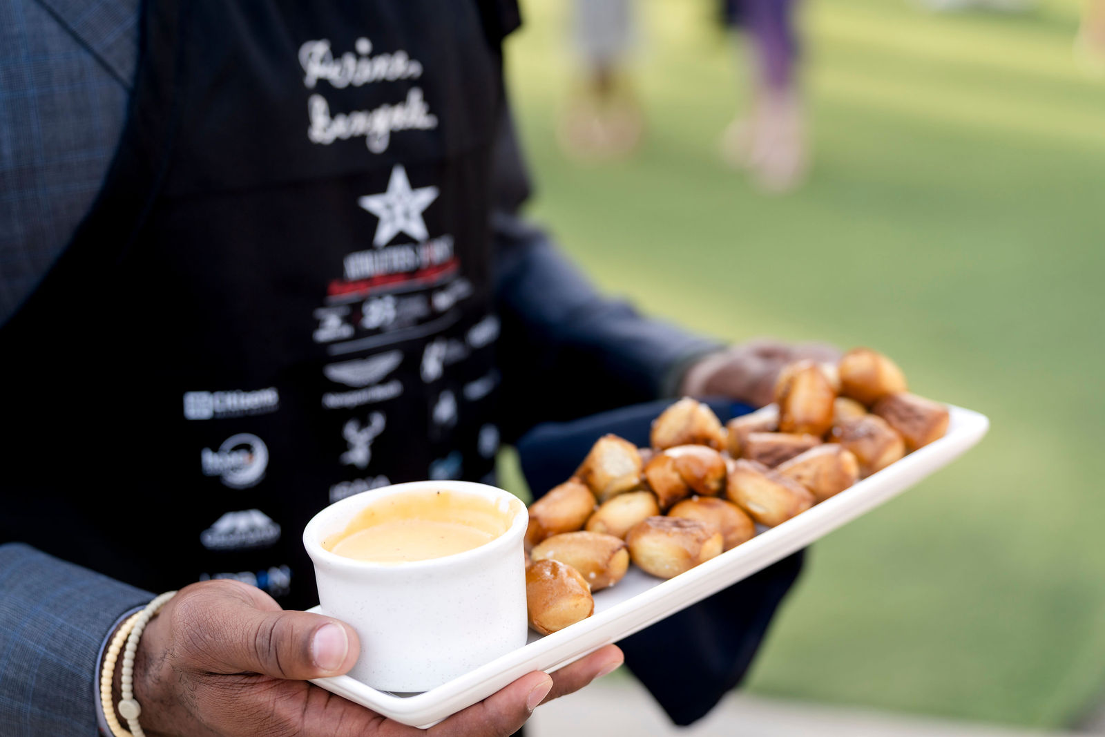 A tray of pretzel bites with cheese sauce