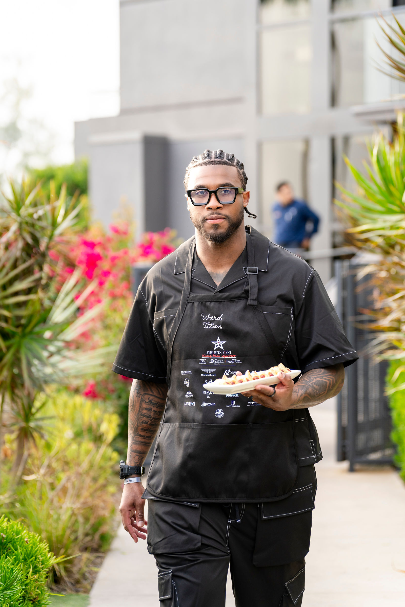 An athlete in a branded apron carrying food