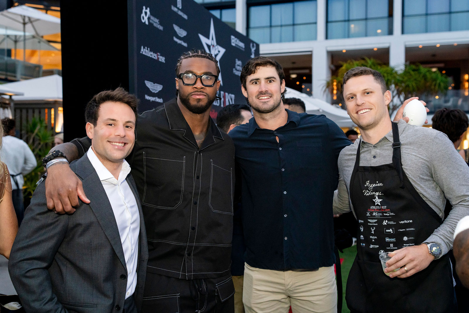An athlete with a group of guests at the backdrop