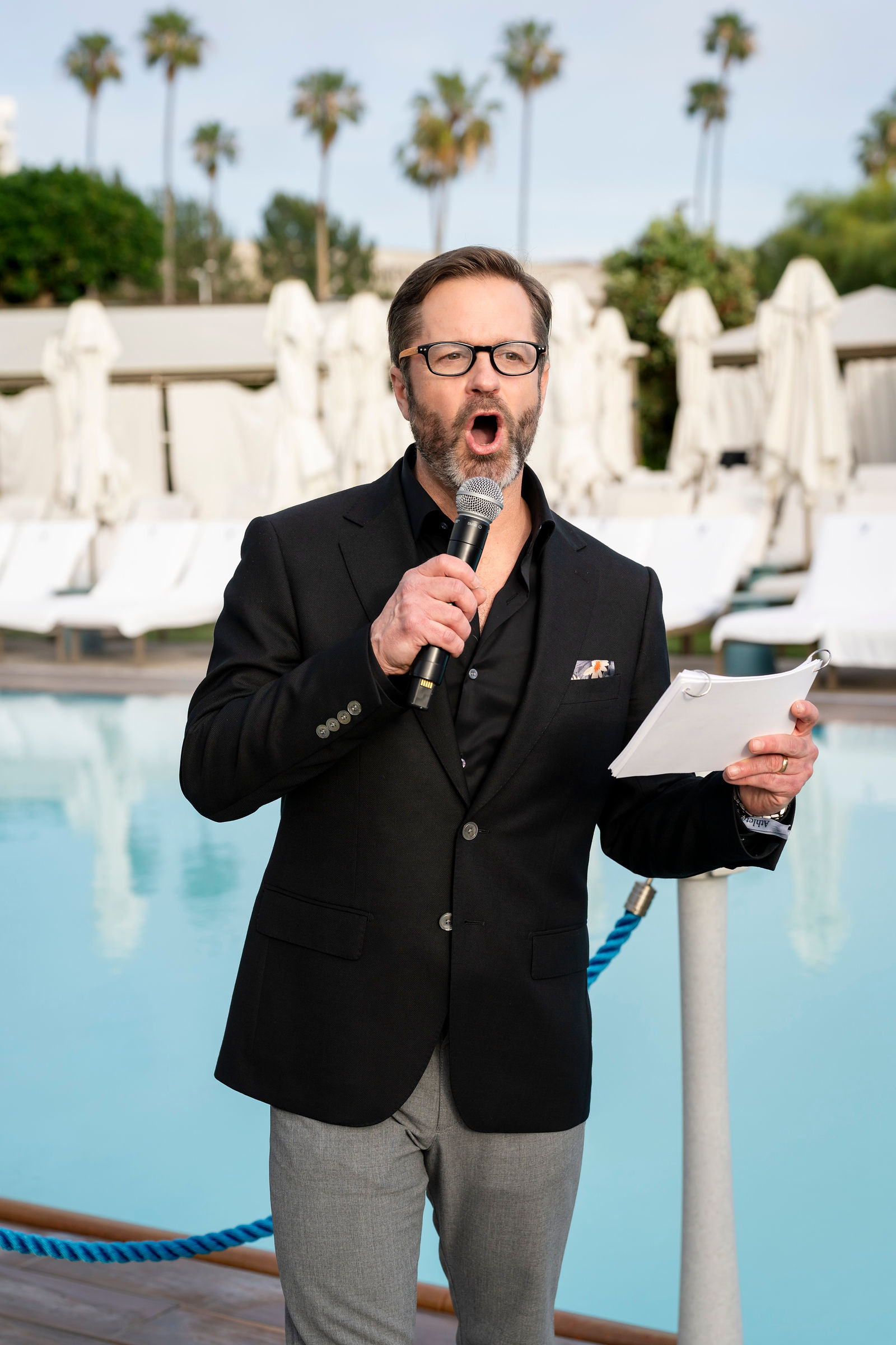 A speaker addressing guests by the pool
