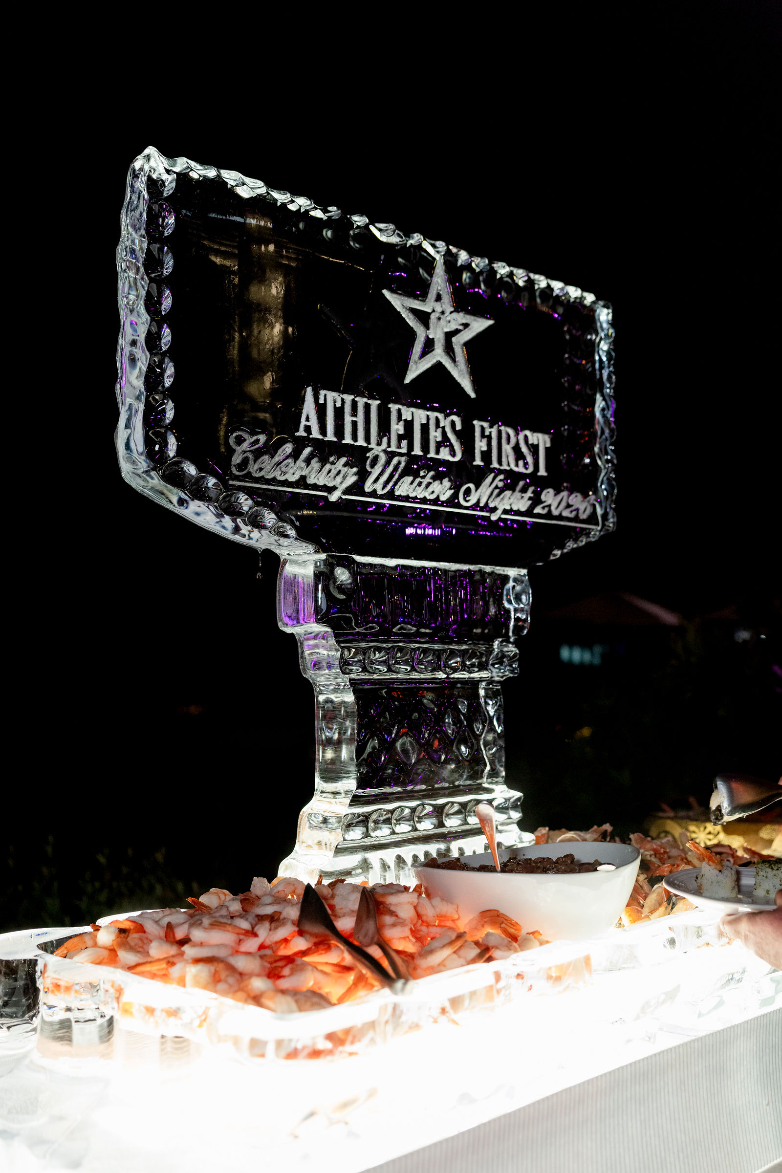 An Athletes First ice sculpture above the seafood station