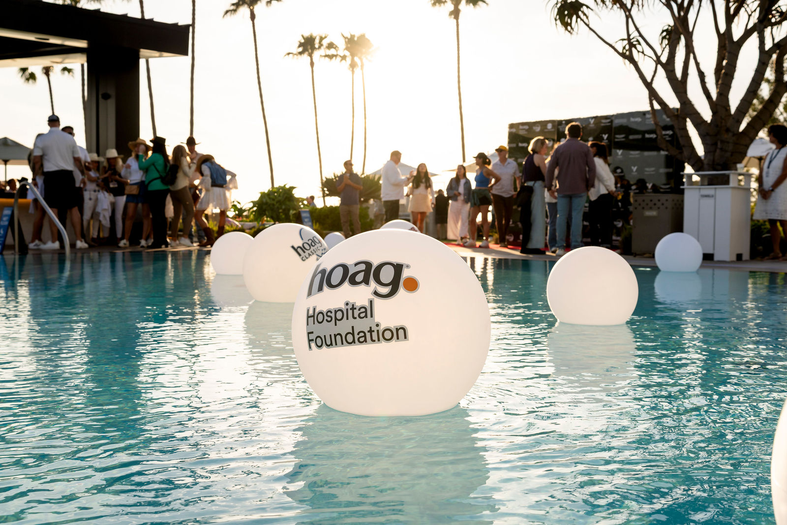 The Hoag Hospital Foundation sphere floating in the pool as guests gather at golden hour
