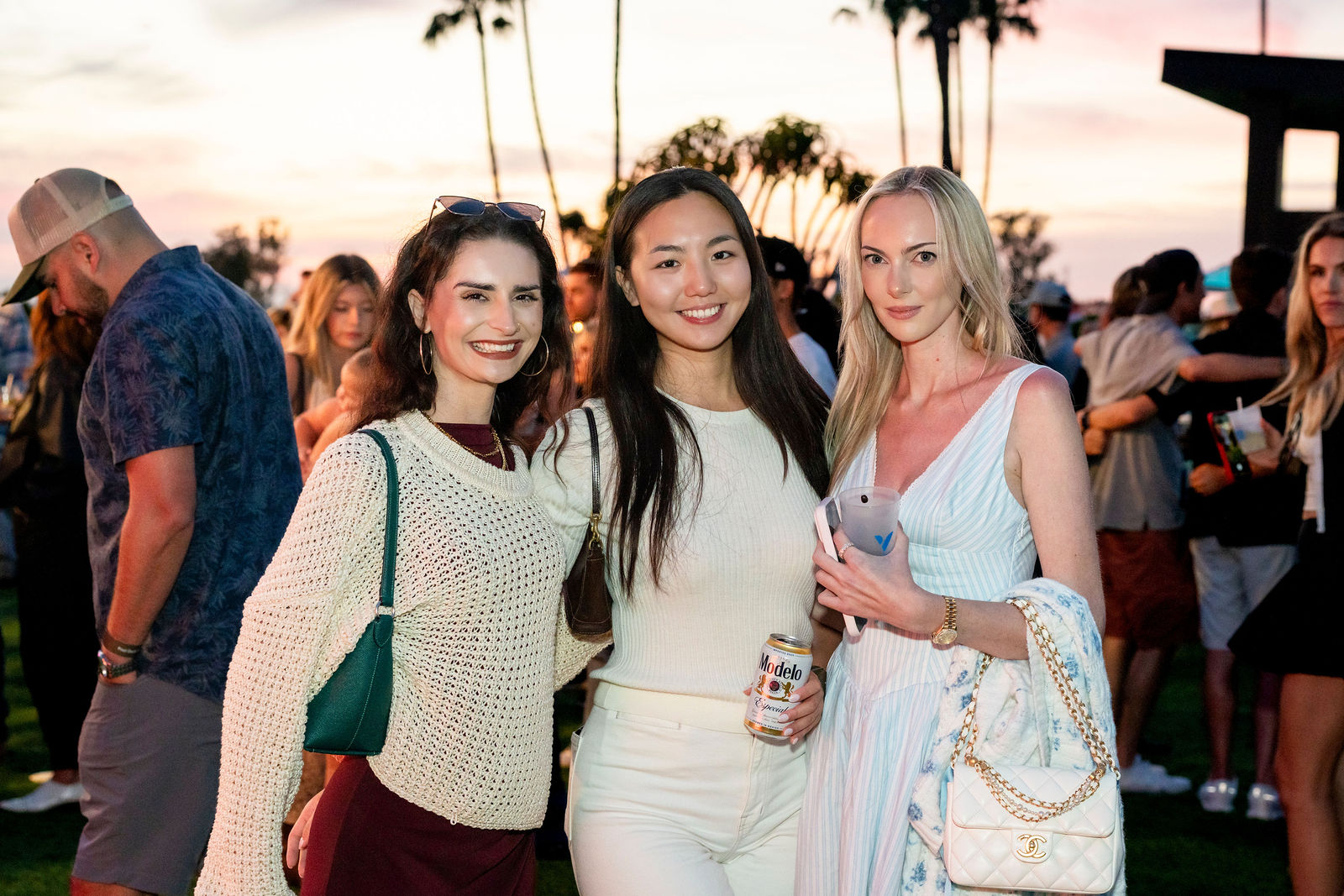 Three guests photographed together under the sunset sky