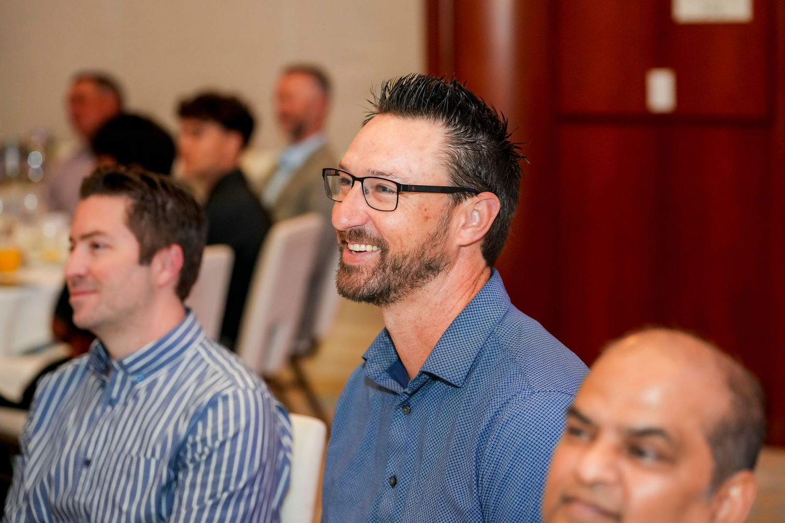 Guests smiling at their table during the community breakfast