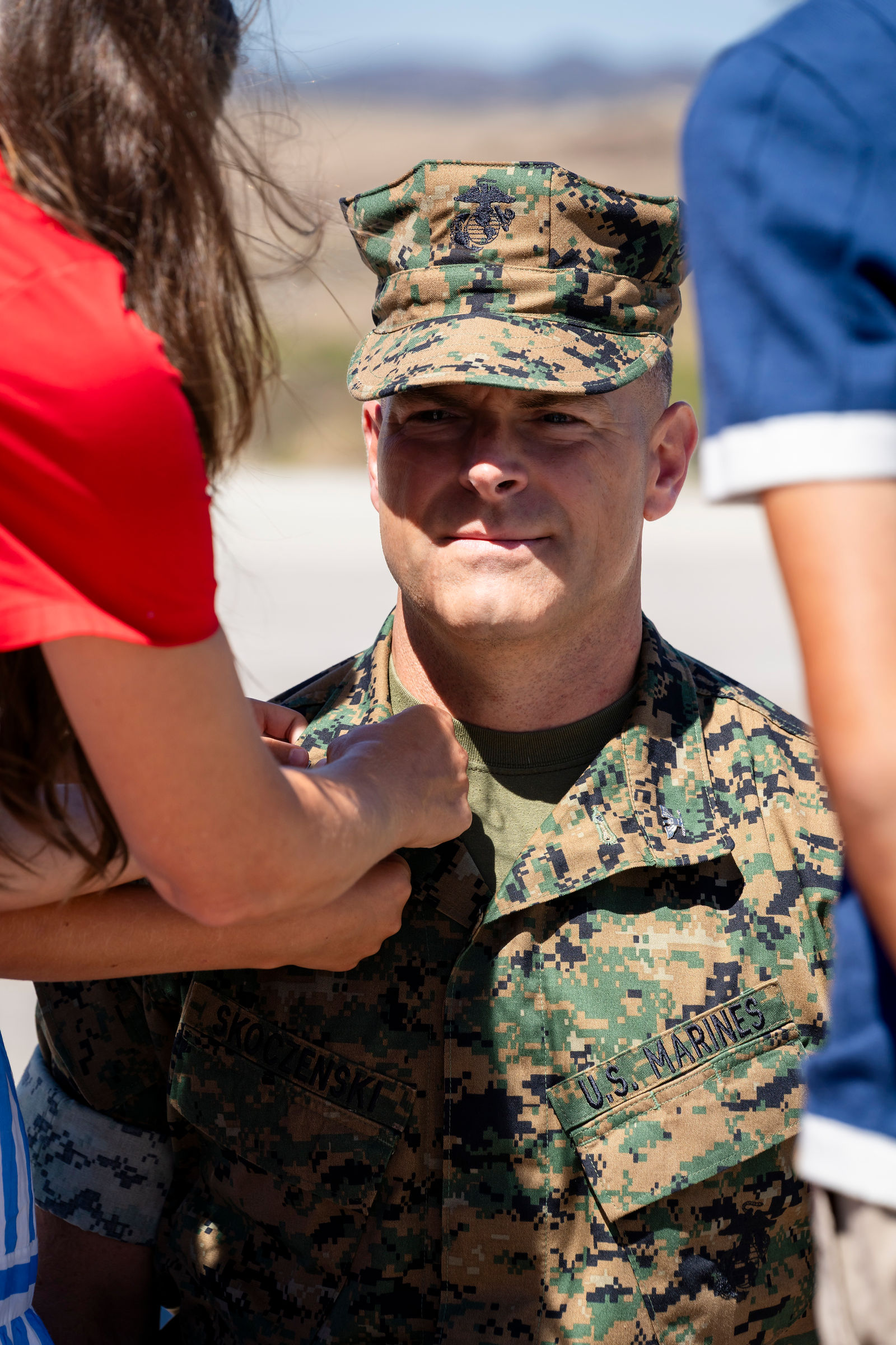Colonel Eric Skoczenski smiling as his family pins on his new insignia