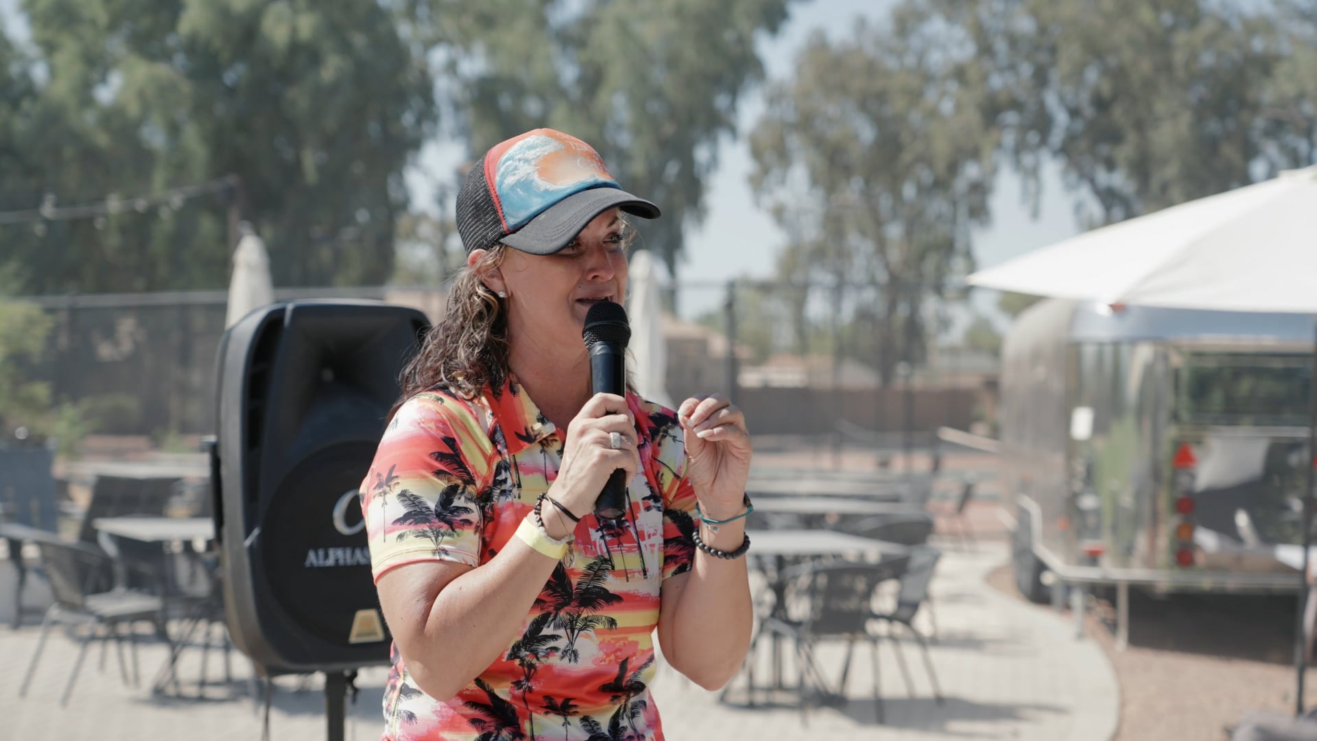 A speaker sharing her story at the mic during The Change Project's golf day