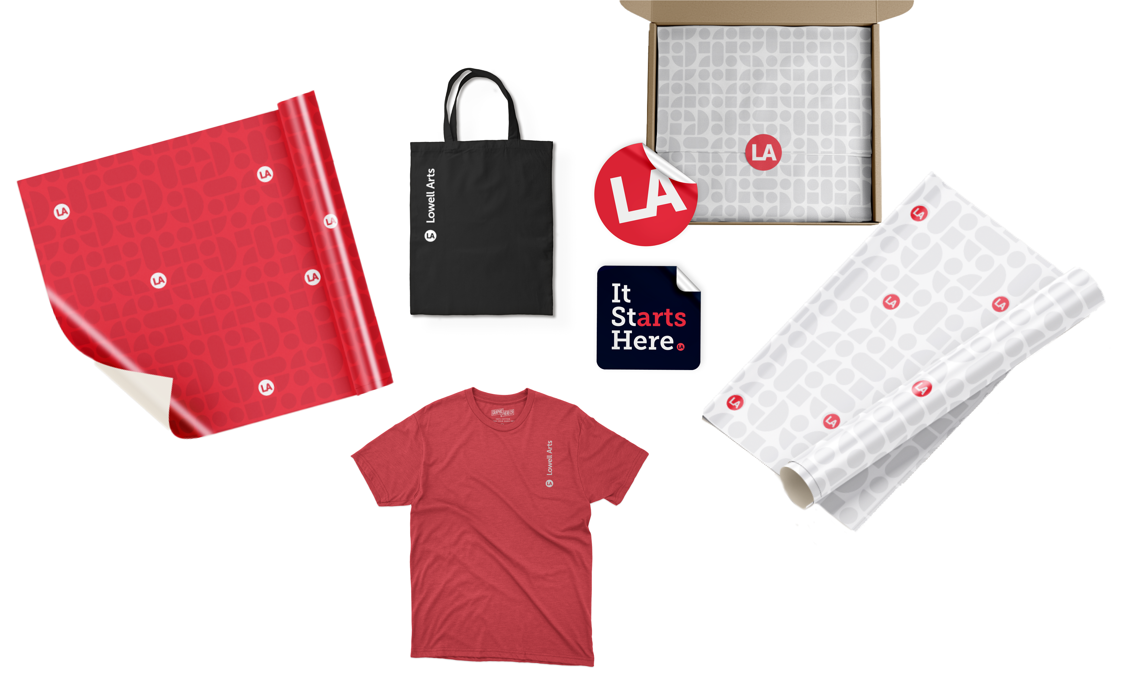 Lowell Arts merchandise: red and light gray patterned wrapping paper with LA badges, a black tote bag, round LA and It Starts Here stickers, a red t-shirt with the vertical wordmark, and a shipping box lined with gray patterned tissue.