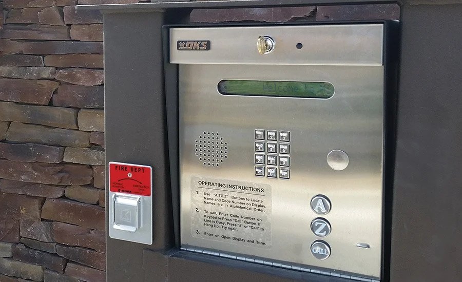 Stainless steel telephone entry call box set in a stone pillar at a gated community