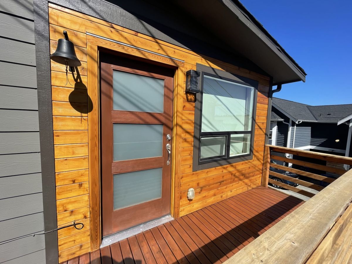 Cedar-clad entry with a stained deck walkway