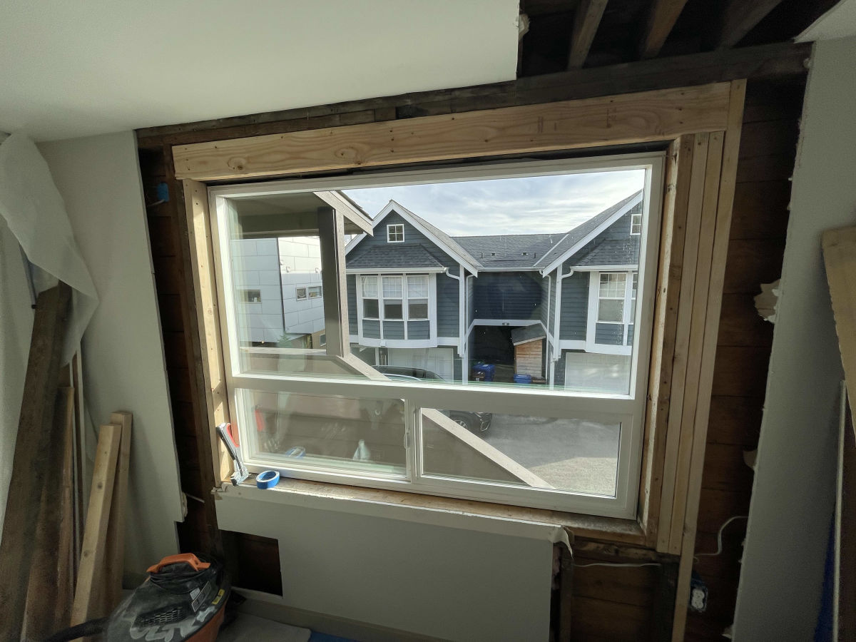 Wall opened up to the studs around a window after water damage