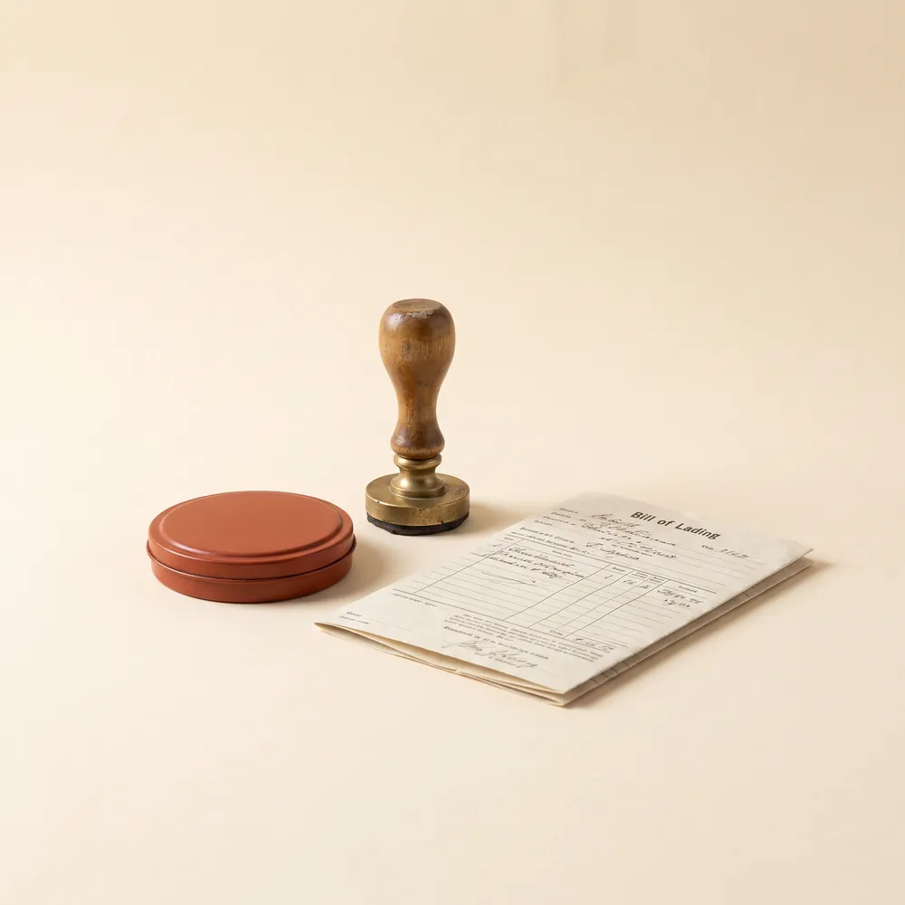 Wooden customs stamp beside a bill of lading