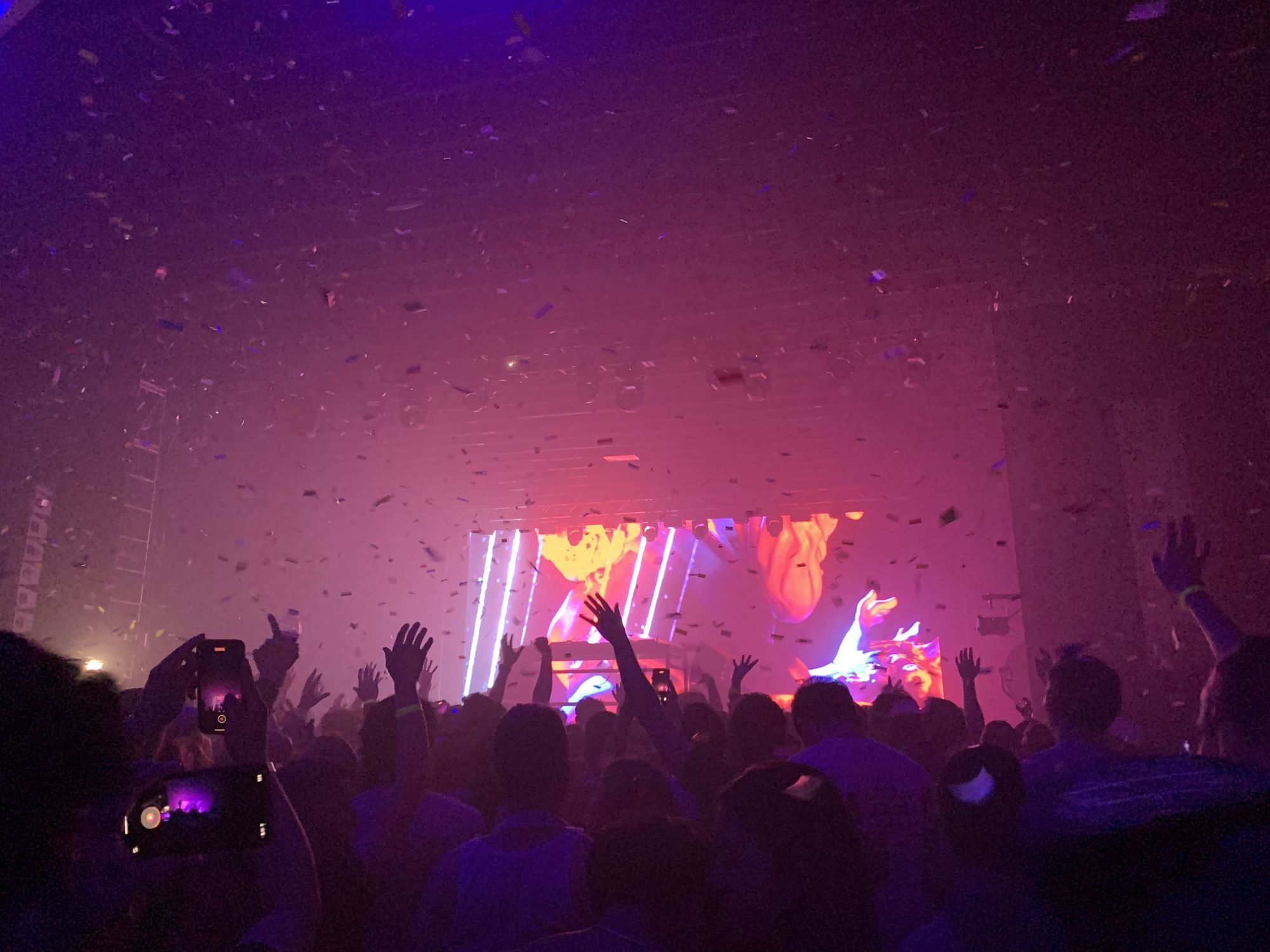 Confetti falling over a backlit crowd at an Okeechobee Music & Arts Festival stage