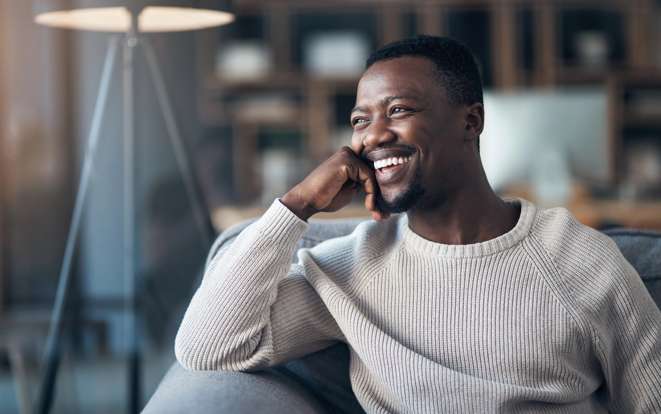 Smiling man talking on the phone at home