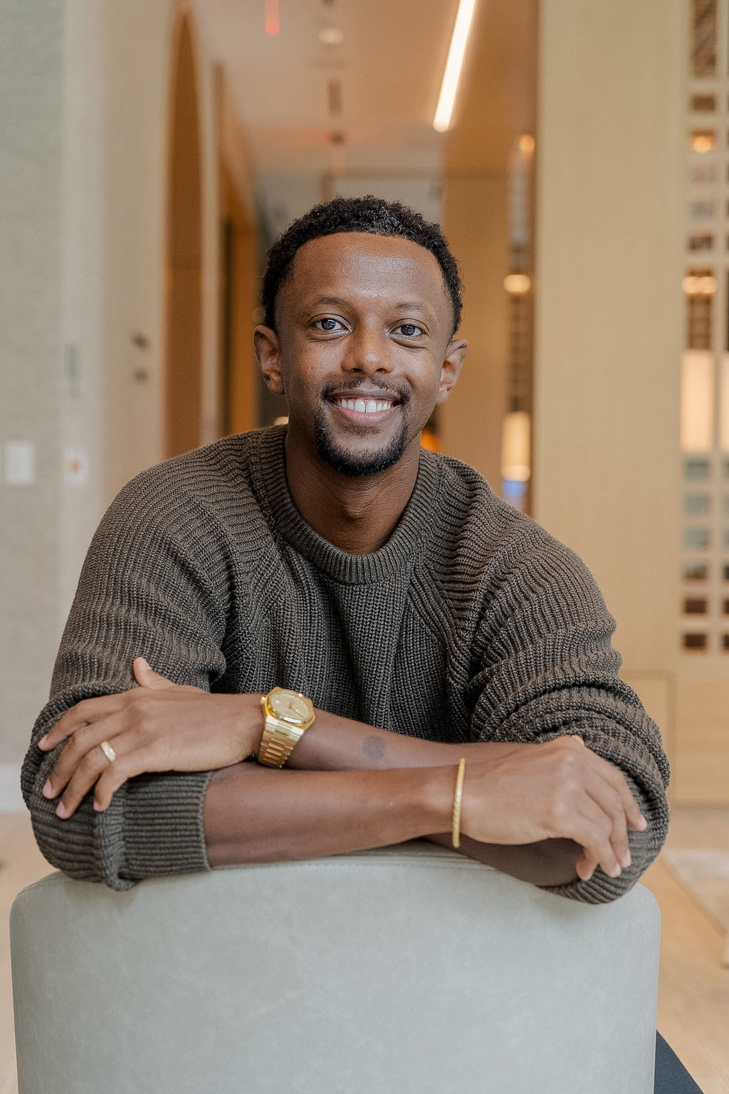 Dr. Yaphet Fisseha smiling, leaning on the back of a chair
