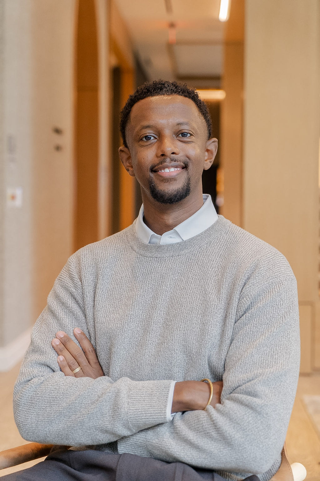 Dr. Yaphet Fisseha, licensed clinical psychologist, seated in a gray sweater