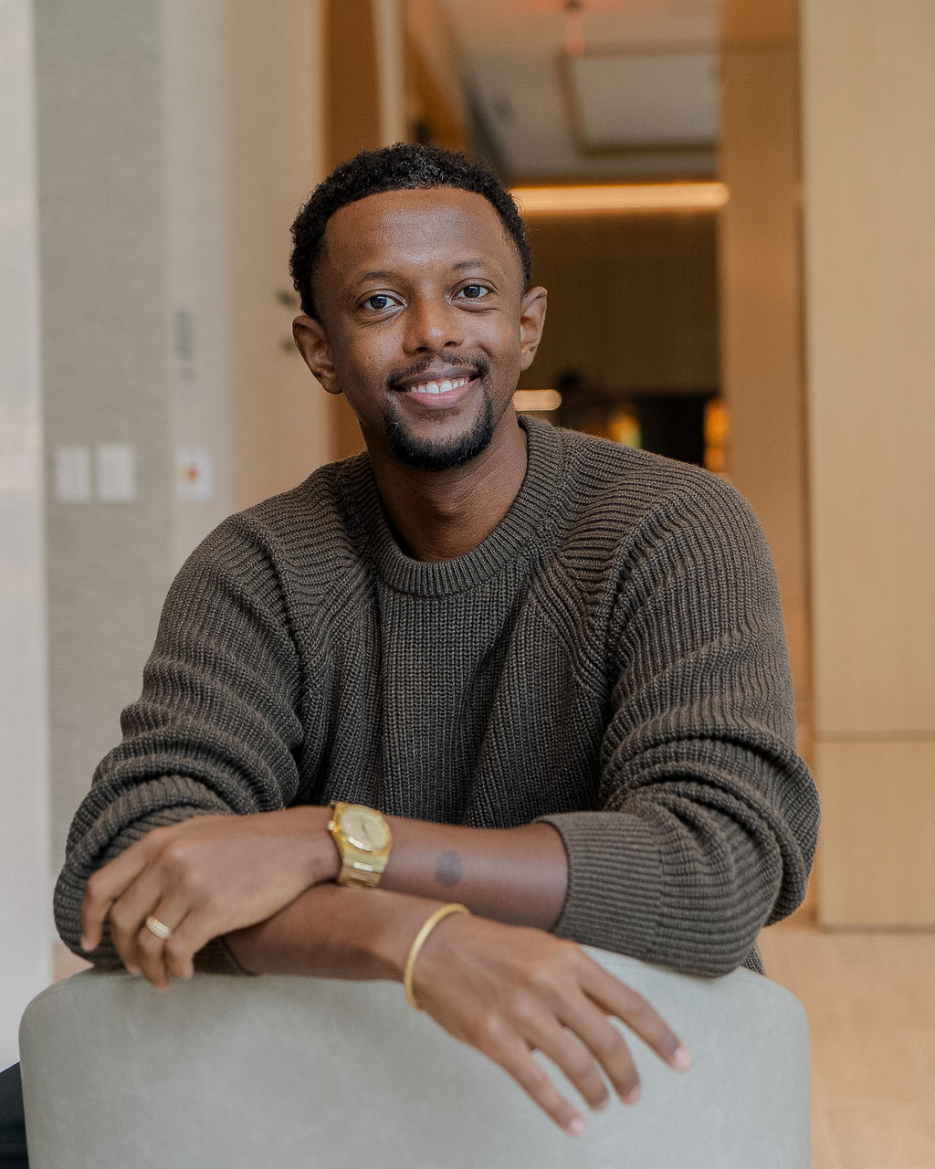 Dr. Yaphet Fisseha smiling, leaning on the back of a chair