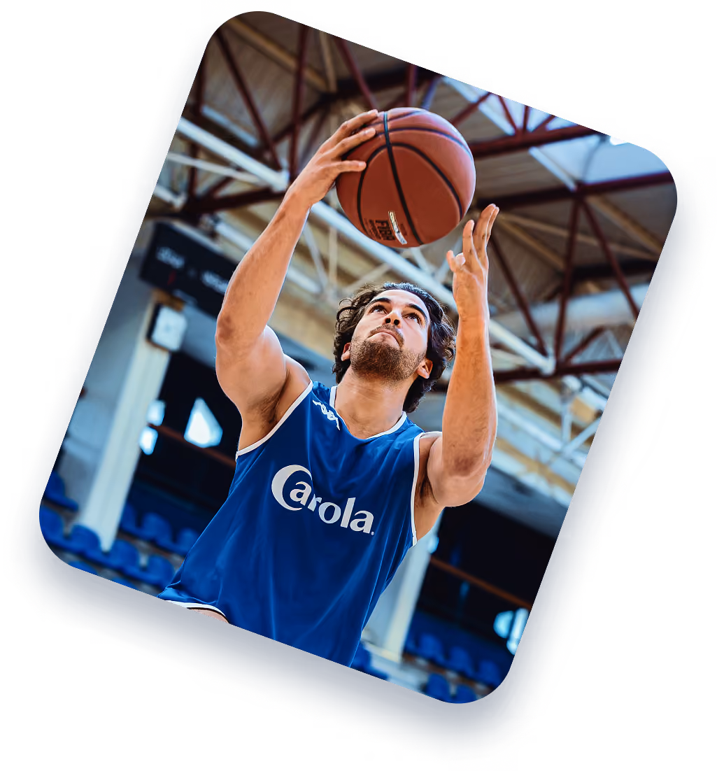 Joueur de basket en maillot Carola au tir dans un gymnase