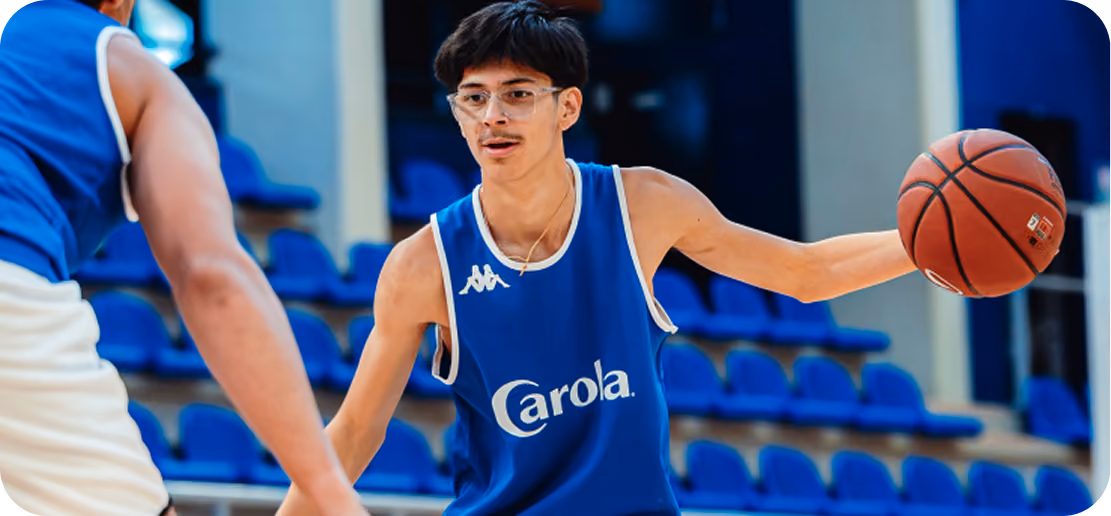 Basketteur en maillot Carola dribblant pendant un match