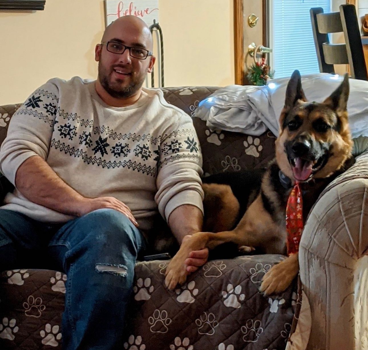 Cody A. Topola, founder of Hexon Tech Services, at home with his German Shepherd