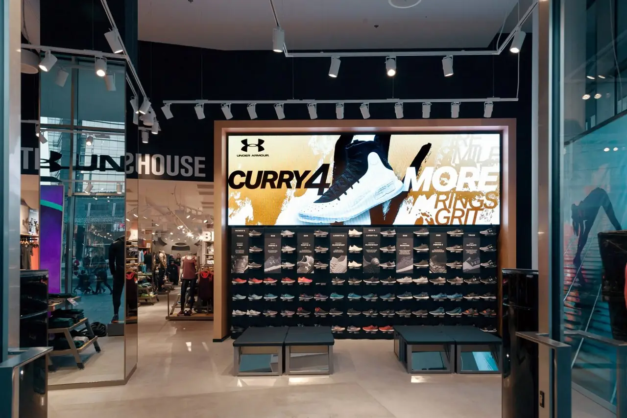 Ledwall sopra la parete delle scarpe in uno store Under Armour