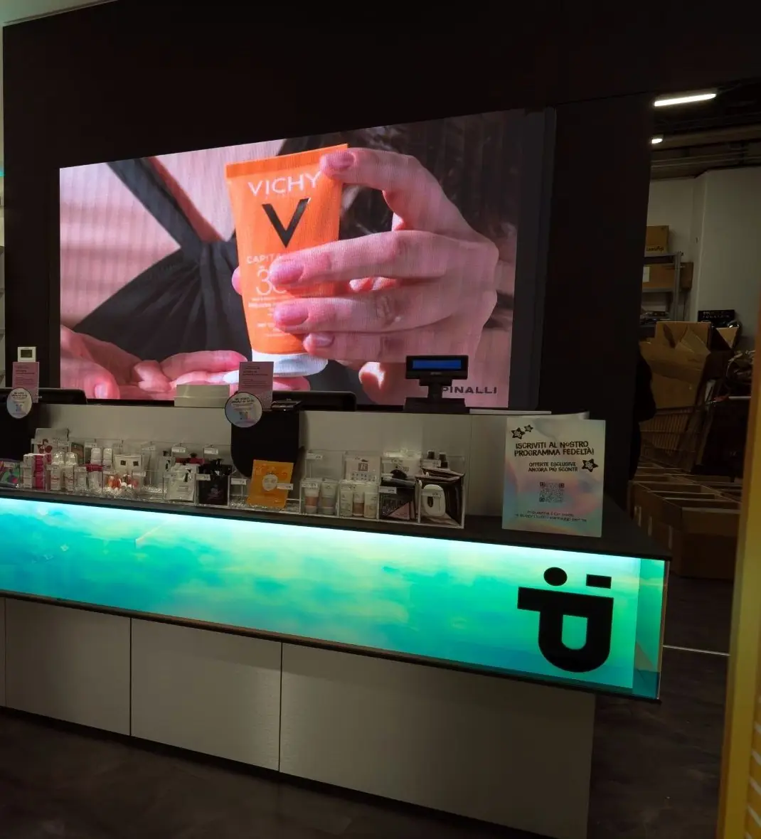 Ledwall dietro il banco cassa di uno store Pinalli