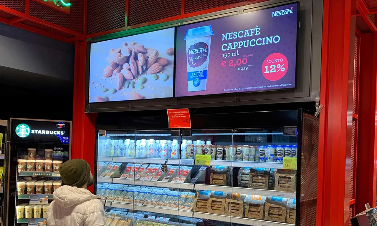 Schermo digitale sopra il banco frigo in un punto vendita Autogrill