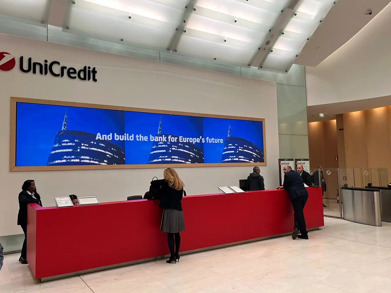 Ledwall panoramico con cornice in legno nella hall UniCredit
