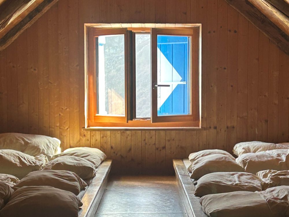 Matratzenlager unter dem Holzdach der SAC-Hütte Capanna Alzasca