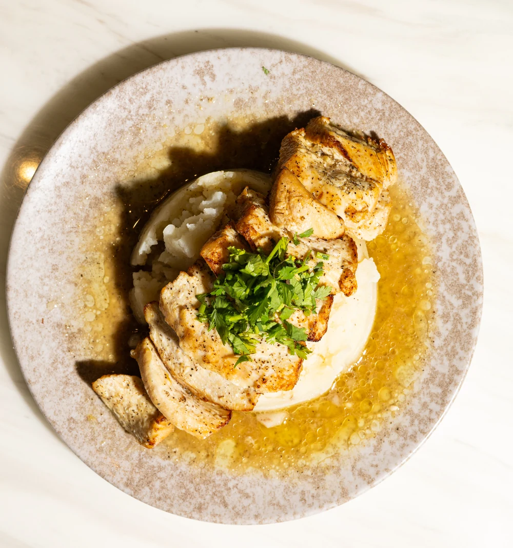 Chicken with mashed potatoes, herbs and sauce at Amand.