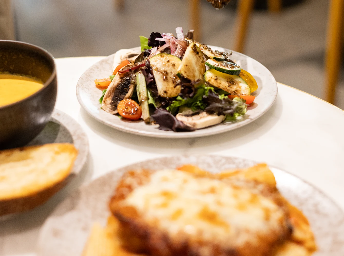 Salad and a toasted sandwich served at Amand.